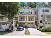 Inviting townhome with an attached one-car garage, a front porch, and a well-manicured lawn at 1537 Liberty Nw Pkwy, Atlanta, GA 30318