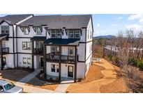 Modern townhome showcasing black-framed windows, black roof, and an inviting covered front porch at 800 Mackay Crk, Woodstock, GA 30188
