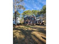 Traditional two-story home with a manicured lawn and a red front door at 9936 Point Vw, Jonesboro, GA 30238