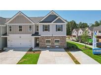 Two-story home with gray siding, brick accents, well-manicured lawn, and an attached two-car garage at 161 Stanchion Dr, Union City, GA 30291