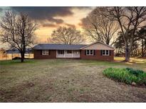 Charming brick home featuring a metal roof and welcoming front porch at 26 Loyd Cemetery Rd, Newborn, GA 30056