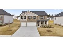 Beautiful two-story brick home with a two-car garage and well-manicured lawn at 1038 Blue Juniper Cir, Loganville, GA 30052