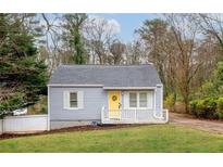 Charming single-story home featuring a welcoming yellow door and a well-maintained front yard at 1707 Terry Mill Se Rd, Atlanta, GA 30316