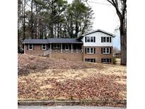 Charming two-story brick home with a welcoming front porch and black shutters at 2724 Hickory Smoke Ct, Snellville, GA 30078