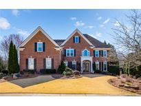 Elegant brick home featuring a well-manicured lawn and a symmetrical facade under a bright blue sky at 2728 Long Grove Dr, Marietta, GA 30062