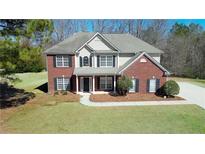 Charming two-story home with brick and siding exterior, complemented by a well-manicured lawn and landscaping at 30 Barbara Ct, Fayetteville, GA 30215