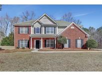 Charming two-story home with brick and siding exterior, black shutters, and well-manicured front yard at 30 Barbara Ct, Fayetteville, GA 30215