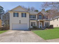 Charming two-story home boasts a well-manicured lawn and attached two-car garage at 318 Farmbrook Pass, Canton, GA 30115