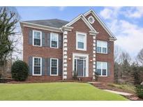 Charming brick home featuring a well-manicured lawn, gray shutters, and meticulous landscaping at 4126 Dream Catcher Dr, Woodstock, GA 30189