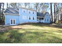 Inviting blue two-story home featuring well-maintained lawn and classic architectural details at 671 Benson Hurst Sw Dr, Mableton, GA 30126