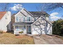 Charming two-story home featuring a two-car garage, well-maintained lawn, and inviting front porch at 826 Shore Dr, Lithonia, GA 30058