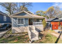 Charming renovated craftsman with inviting front porch, blue siding, and concrete stairs at 1015 Michigan Nw Ave, Atlanta, GA 30314
