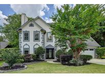 Charming home featuring gray trim, a well-manicured lawn, and lush landscaping for enhanced curb appeal at 5080 Firelight Ln, Alpharetta, GA 30022