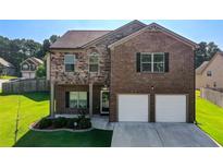 Beautiful two-story brick home featuring a well-manicured lawn and an attached two-car garage at 6101 Providence Way, Union City, GA 30291