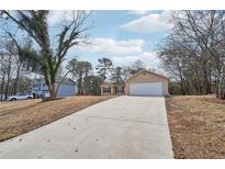 Wide driveway leads to this quaint single-story home featuring a two car garage at 2426 Windridge Dr, Conyers, GA 30013