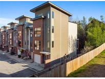Modern townhome exterior featuring a brick facade, gray siding, and a private garage at 975 Moda Drive Dr, Atlanta, GA 30316