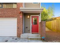 Inviting townhome entrance featuring a red door, brick accents, and modern design at 975 Moda Dr, Atlanta, GA 30316