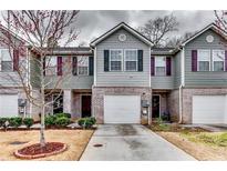 Inviting townhome exterior features gray siding, brick accents, an attached garage, and well-maintained landscaping at 1155 Magnolia Gardens Walk, Mcdonough, GA 30253