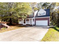 Charming two-story home with a well-manicured lawn, attached garage, and inviting front porch at 995 Brighton Cove Trl, Lawrenceville, GA 30043