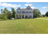 Charming two-story home featuring a well-manicured lawn and inviting curb appeal with a covered front porch at 8050 Tristan Way, Whitesburg, GA 30185