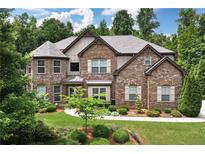 Beautiful two-story brick home showcasing manicured landscaping, and a blend of stone and siding at 2196 Abbott Dr, Buford, GA 30519