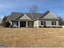 Charming single-story home with a welcoming front porch, manicured lawn, and classic design elements at 1162 Mason Lee, Loganville, GA 30052