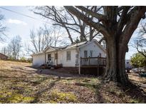Charming cottage-style home featuring a front deck and surrounded by mature trees at 51 Daisy Cir, Canton, GA 30114