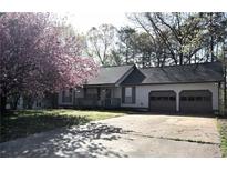 Charming single-story home featuring a two-car garage, covered porch, and blossoming tree in the front yard at 184 Brandywine Dr, Douglasville, GA 30134