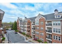 Upscale condominium exterior featuring a brick facade, multiple balconies, and well-maintained landscaping at 1850 Cotillion Dr # 3222, Atlanta, GA 30338
