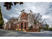 Brick condo building with arched entrance, manicured landscaping, and convenient parking at 1850 Cotillion Dr # 3222, Atlanta, GA 30338