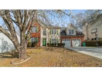 Charming two-story home with a brick and siding facade, green shutters, attached two-car garage, and mature trees at 5706 Spring Mill Cir, Lithonia, GA 30038