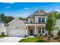 Charming two-story home with a light brick facade, attached two-car garage, and well-maintained landscaping at 1465 Auburn Glen Rd, Dacula, GA 30019