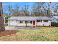 Charming single-story home featuring a brick facade, red door, and well-maintained front yard at 1643 Pine Glen Cir, Decatur, GA 30035