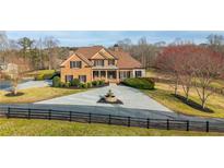 Stately brick home with manicured landscaping, fountain, and a circular driveway at 714 Billings Farm Ln, Canton, GA 30115