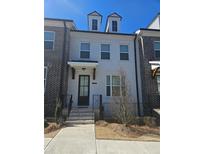 Charming three-story home featuring a well-manicured front yard and classic architectural details at 1309 Bennett Creek Ovlk, Suwanee, GA 30024