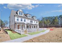 Charming new construction townhome showcasing brick accents and white picket fence at 208 Village Overlook # J3, Canton, GA 30114