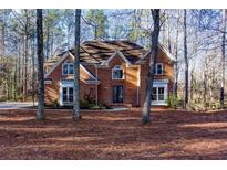 Charming brick two-story home with manicured lawn and mature trees, perfect for a growing Gathering at 4811 Cross Creek Ct, Kennesaw, GA 30152