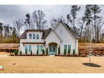 Beautiful white brick home with manicured landscaping and inviting blue front door at 4750 Fields Bridge Rd, Cumming, GA 30028