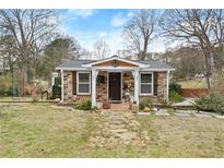 Charming stone-clad cottage with a welcoming front yard and quaint pathway at 1164 Sandtown Sw Rd, Marietta, GA 30008