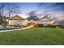 Beautiful home exterior at twilight with a green lawn, mature landscaping, and inviting lighting at 180 Saddle Creek Dr, Roswell, GA 30076