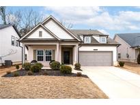 Charming single-Gathering home featuring a two-car garage, manicured front yard, and a welcoming entrance at 5650 Bergeson Way, Cumming, GA 30028
