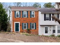 Inviting two-story brick townhouse with classic shutters and well-manicured landscaping at 1540 Cedar Bluff Trl, Marietta, GA 30062