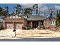 Charming brick home with manicured lawn, mature trees, and a two-car garage at 104 Big Meadows Dr, Canton, GA 30114