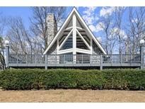 A-frame home featuring a stone chimney, large A-frame windows, and a spacious gray wraparound deck at 1364 Tsali Trl, Morrow, GA 30260