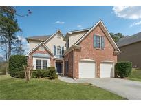 Charming two-story brick home with a well-manicured lawn and attached two-car garage at 2815 Chandler Grove Dr, Buford, GA 30519