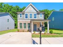 Charming two-story home with brick and gray siding, covered porch, and well-manicured front lawn at 1947 Thomasville Estate Dr, Atlanta, GA 30315