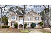 Charming home with stone accents, a well-manicured lawn, and mature trees at 1345 Smoke Hill Dr, Hoschton, GA 30548