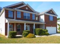 Charming brick two-story home with well-manicured front lawn and attached two car garage at 490 Hinton Chase Pkwy, Covington, GA 30016