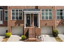 Charming brick townhome with inviting entrance, classic architectural details and attached garages at 1583 Mosaic Way, Smyrna, GA 30080