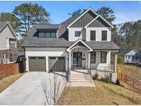 Charming two-story home featuring a symmetrical design, three-car garage and a well-manicured front lawn at 1857 Defoor Ave, Atlanta, GA 30318
